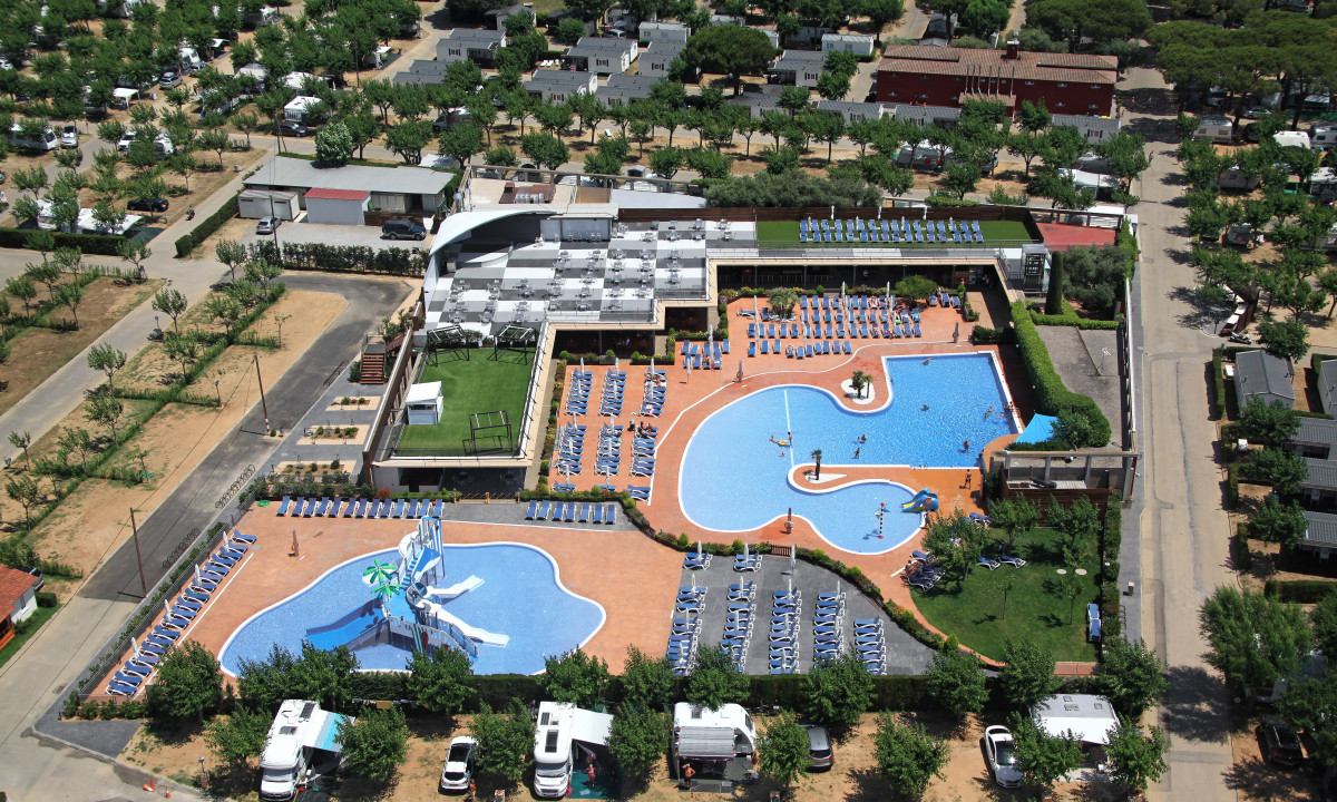Aerial view of large pools with slides and sun loungers, surrounded by trees and camping areas at Eurocamping