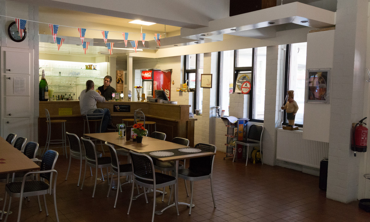 At het Veen, two individuals are conversing in a cozy indoor seating area adorned with patriotic decorations.