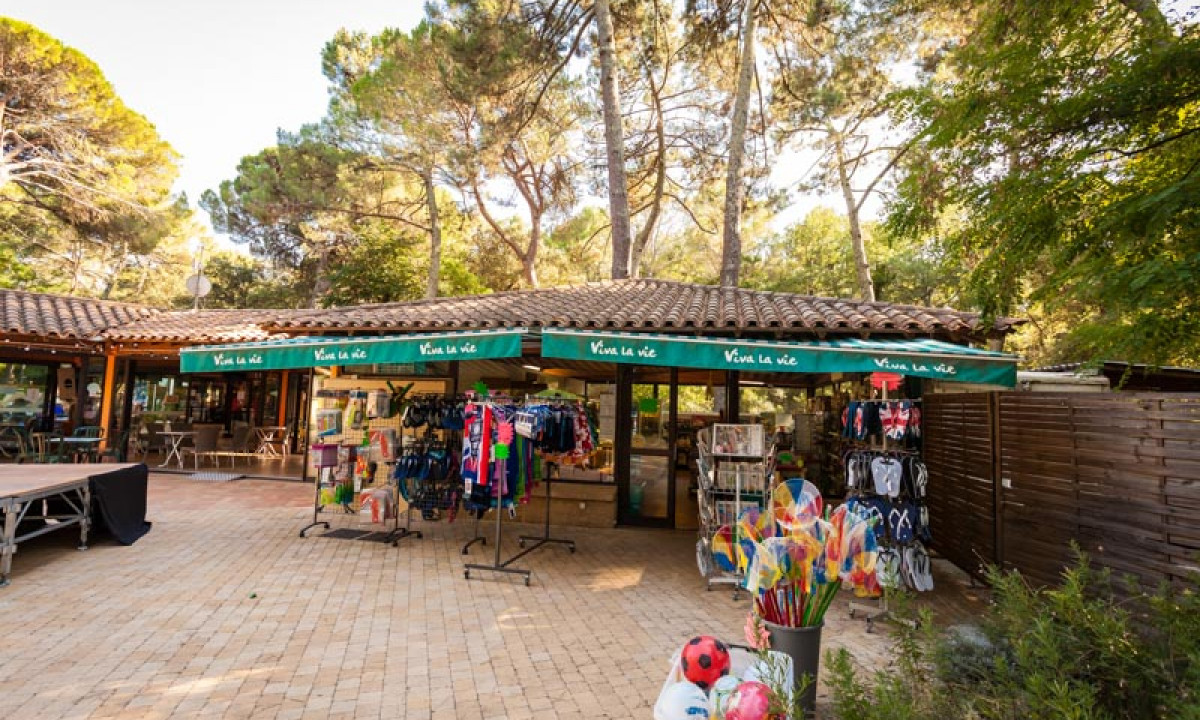 At La Sousta, there are merchandise displays surrounded by towering trees.