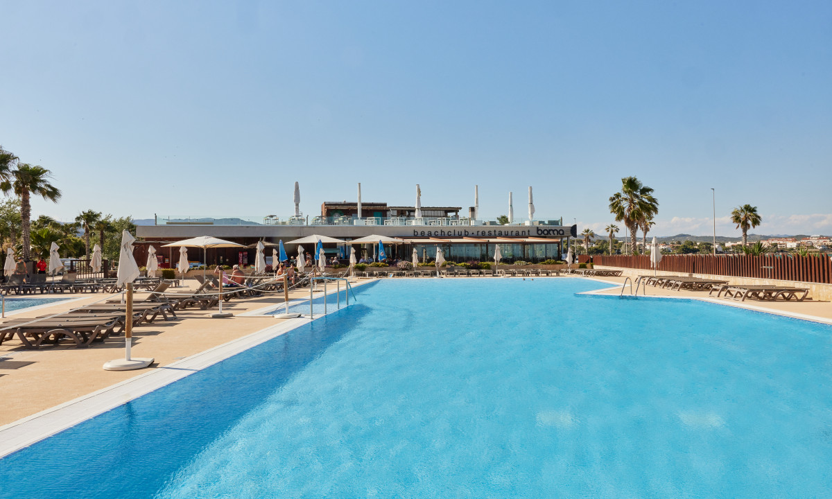 At Taïga Delta De L'Ebre, a pristine azure swimming pool, encircled by sunbeds and parasols, is situated close to a seaside eatery.