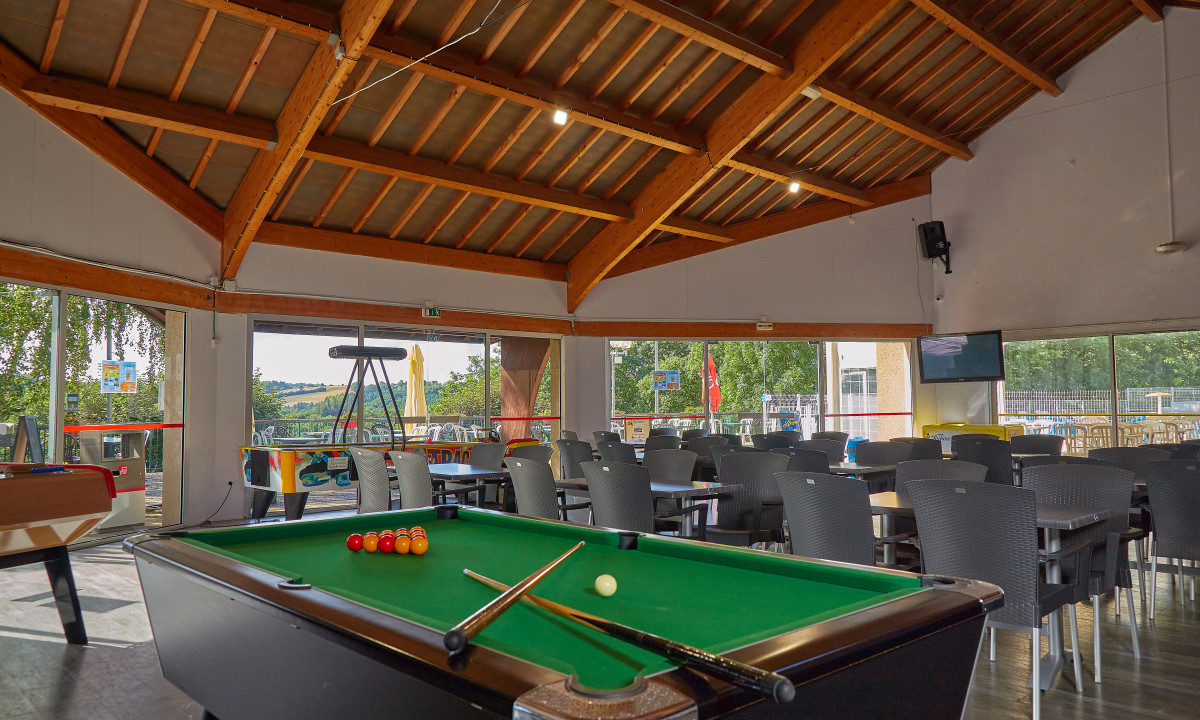 At Terrasses du Lac, there is a billiard table accompanied by cue sticks and balls in a spacious sheltered recreational space featuring seating and outdoor vistas.