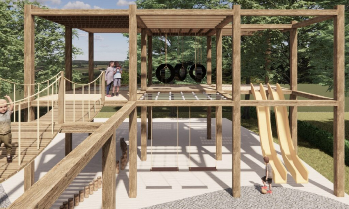 At Urban Gardens Gent, children are enjoying themselves on a wooden play structure featuring slides, bridges, and swings, encircled by vibrant greenery.