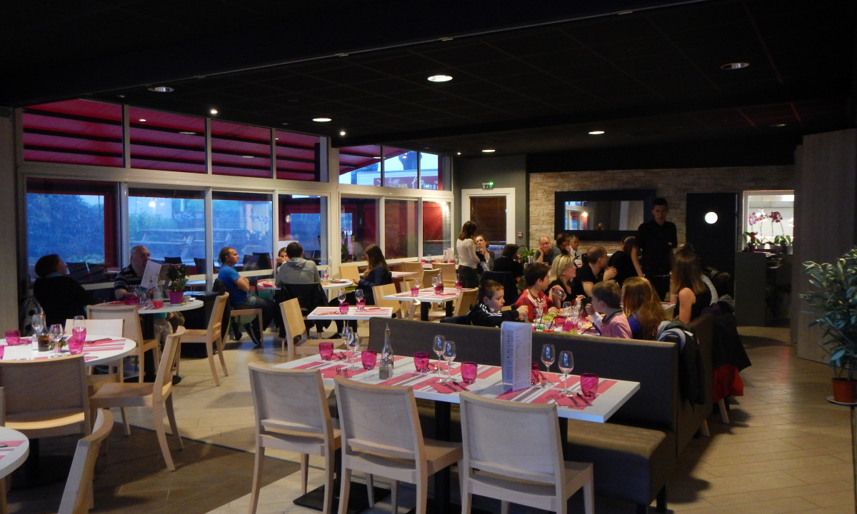 At Le Domaine de Léveno, patrons are savoring their dishes at tables in an eatery featuring contemporary decor.