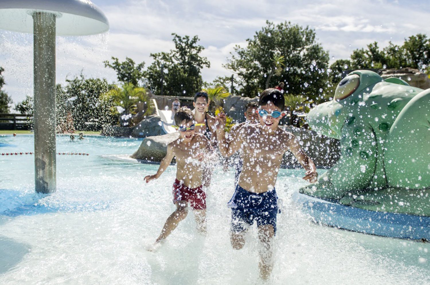 At Bois de Valmarie, kids dash and splash in a water park zone adorned with whimsical sculptures and water features.